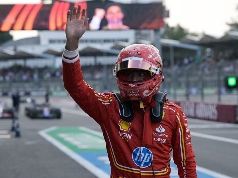 Ferrari's Spanish driver Carlos Sainz waves after taking pole position in the qualifying session