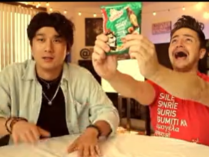 Two guys at a table about to eat Simba Chips