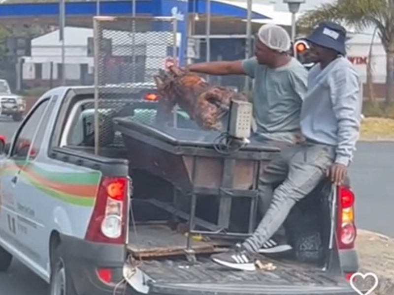 Two guys braai at the back of a bakkie