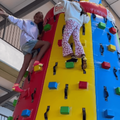 Two kids climb up a bouncy climbing wall in Ballito