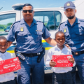 Two police officers standing with two school kids and their new school shoes