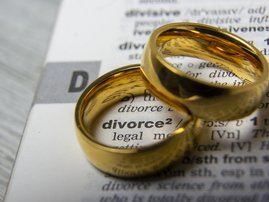 Two rings places on top of dictionary with the word divorce written on it