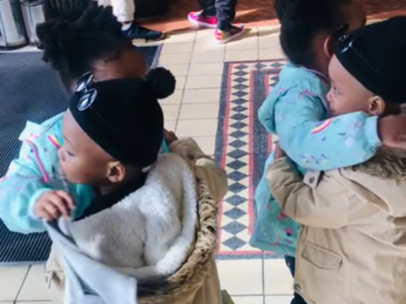 Two sets of twins hug each other at a mall