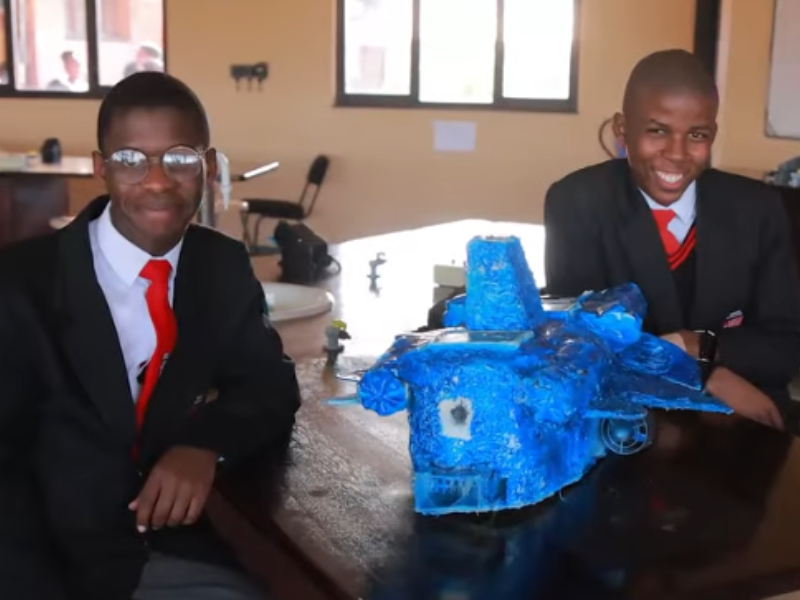 Two students from Adams College in KZN sit with their robot invention