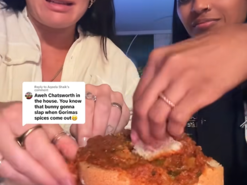 Two women enjoy a mutton curry bunny chow together