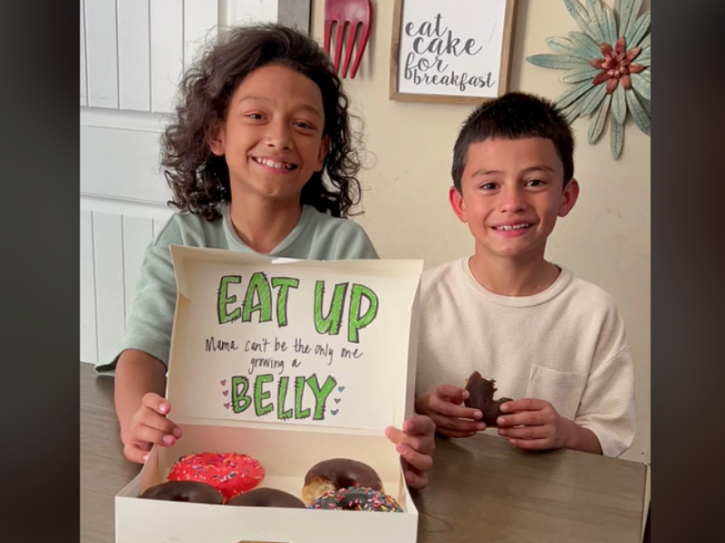 Two young boys posing with donuts