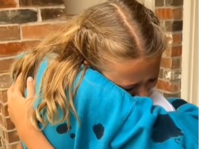 Two young girls hug each other