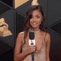 Tyla holding a mic with a Grammys logo