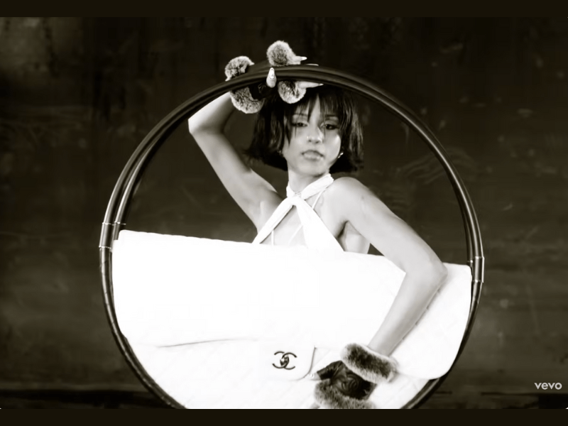 Tyla posing with a Chanel hula-hoop bag