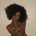 Tyla with voluminous curly hair poses against a wall