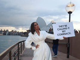 Tyra Banks wearing a white coat near the Sydney Opera House