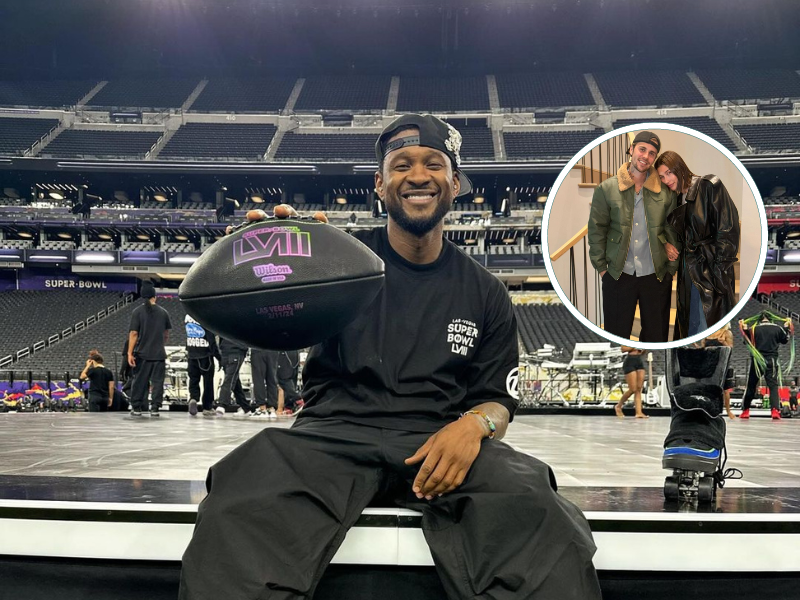Usher holding up a black NFL ball while sitting on a stage.