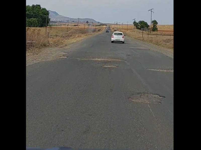 Vehicle driving on a road filled with potholes