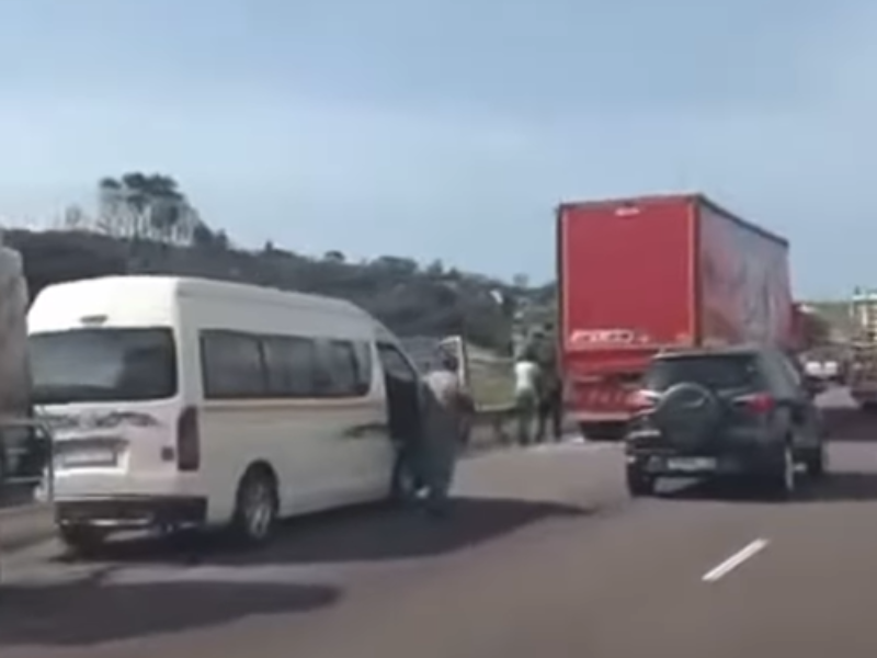 Vehicles slowing down on the N2 South Coast KZN as pedestrians begin looting a beer truck
