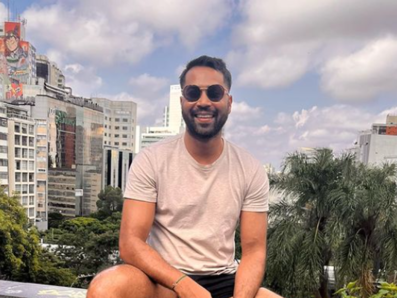 Vic Naidoo seated on a wall in Sao Paulo