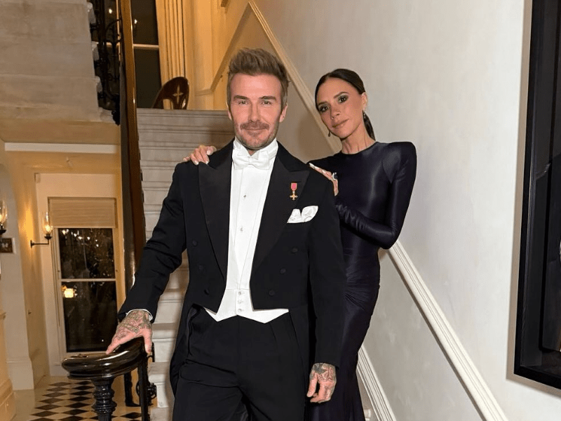 Victoria and David Beckham posing at the bottom of a staircase