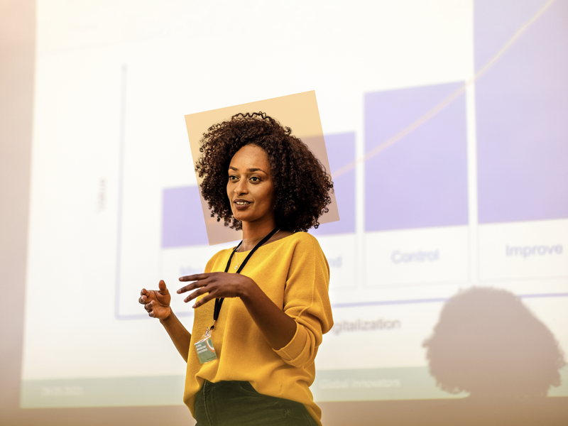 WOMAN GIVING SPEECH AT BUSINESS CONFERENCE