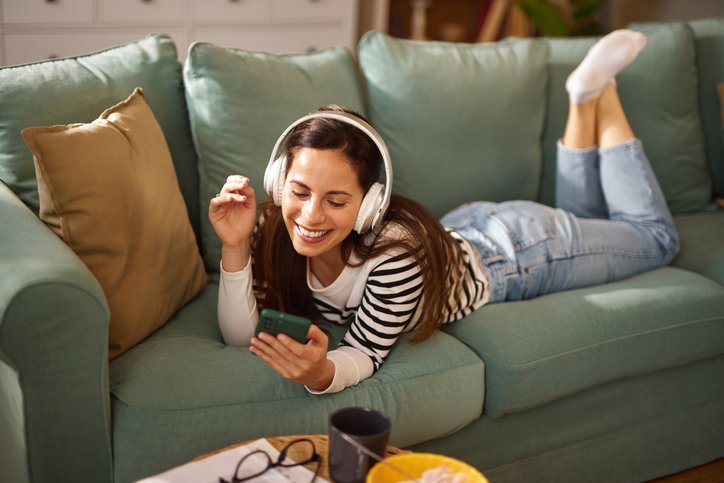 WOMAN LISTENING TO MUSIC ON COUCH