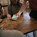 Waiter hands the bill to a table of customers