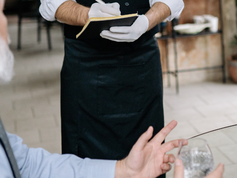 Waiter taking order for couple at restaurant