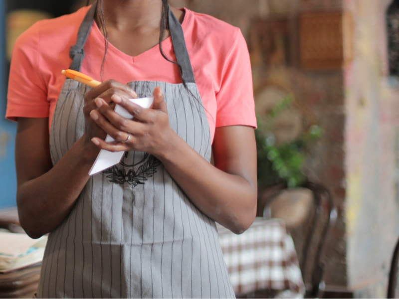 Waitress writing on white paper at a restaurant