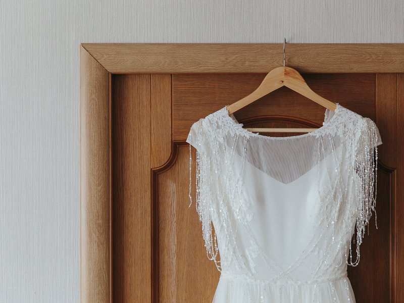 Wedding dress hanging on a hanger on the door iStock
