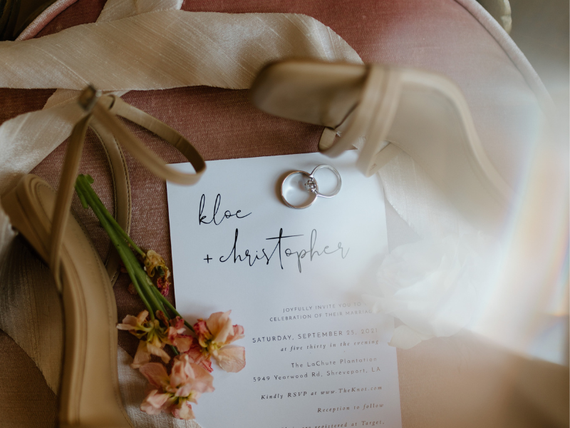 Wedding rings and flowers and an invitation