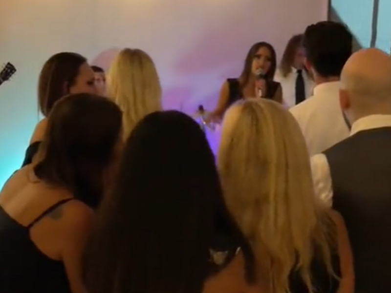 Wedding singer singing at reception with crowds of guests