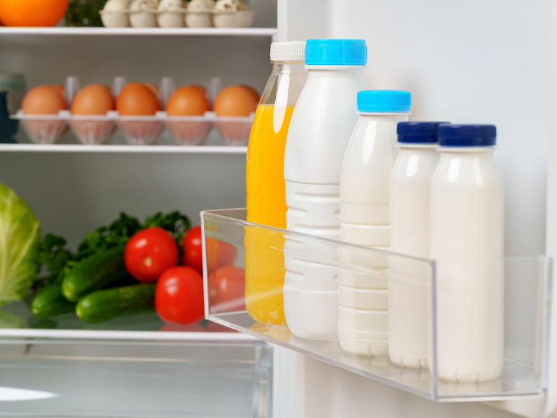 White fridge open with fresh produce and dairy