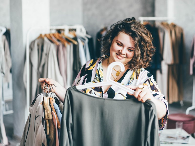 Woman Choose Fashioned Dress in Store/ iStock