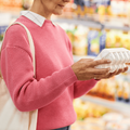 Woman check expiry date of eggs in grocery store