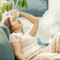Woman cools down next to a white fan