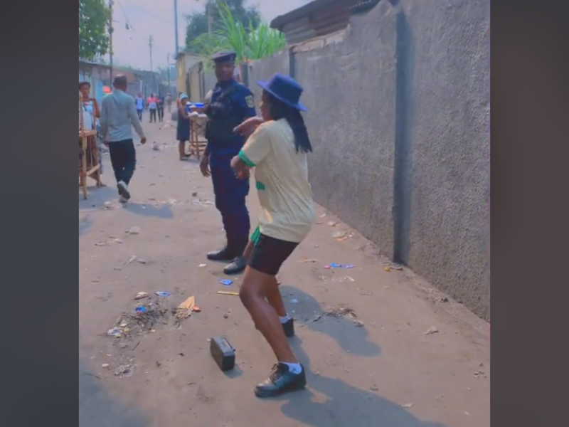 Woman dancing for a police officer on street