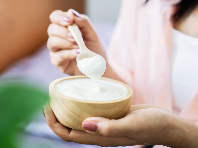 Woman eating plain yoghurt iStock