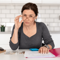 Woman goes through her finances while sitting in a kitchen