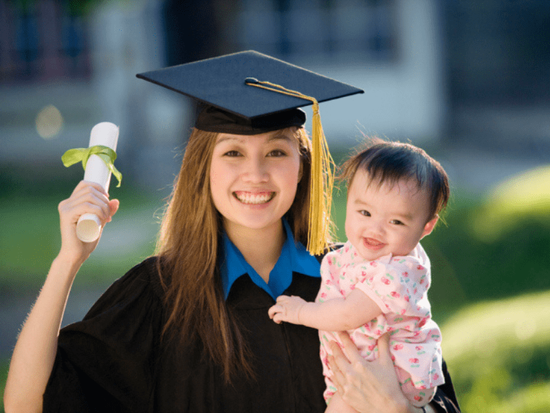 Woman graduate holding baby