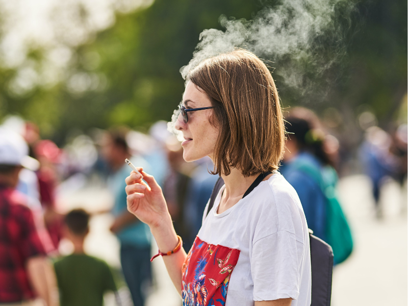 Woman holding a cigarette in a public area