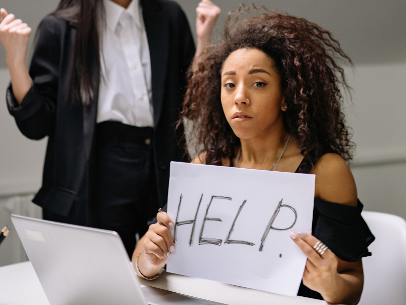 Woman holding a paper in front of a laptop