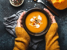 Woman holding butternut soup in a bowl