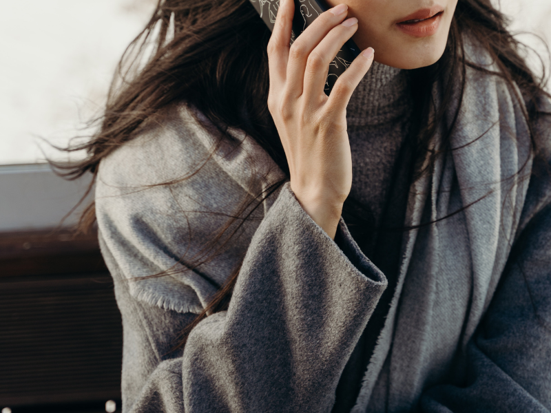 Woman in gray sweater talking on the phone