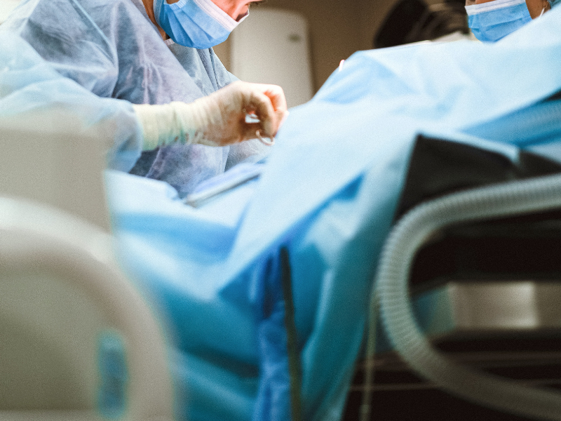Woman in medical scrub performing surgery
