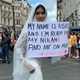 Woman in wedding dress holding up a sign