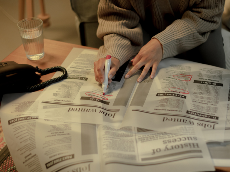 Woman looking for jobs in newspaper