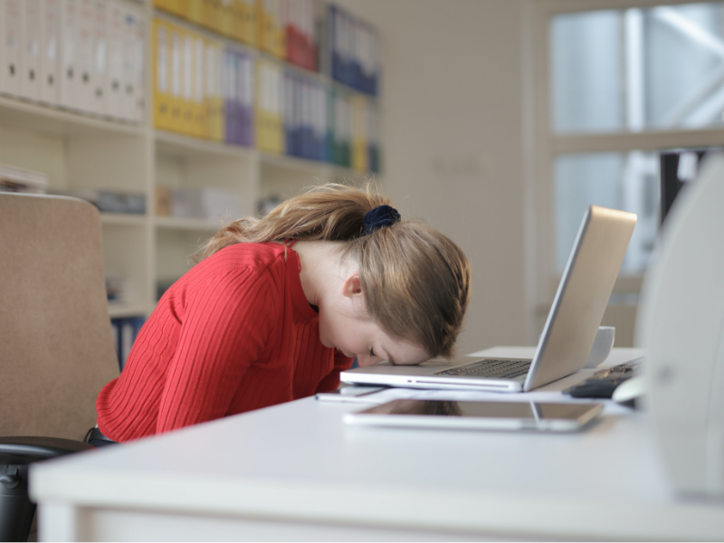 Woman sitting on chair with her head on the laptop