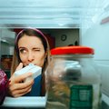 Woman smelling a milk carton to see if it has expired