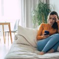Frustrated and depressed young brunette woman is crying with a smartphone in hands / iStock