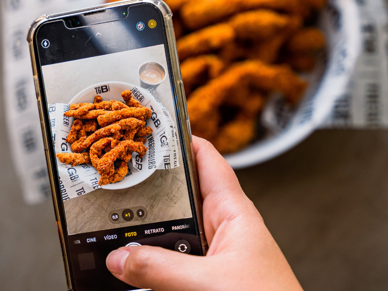 Woman taking photo of food with mobile phone