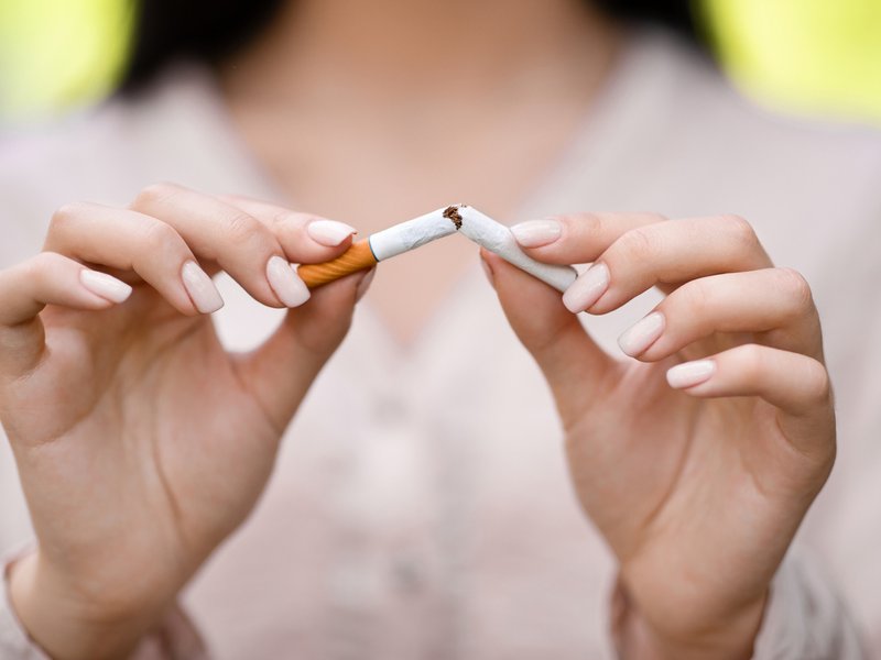 Woman using her hands to break cigarette