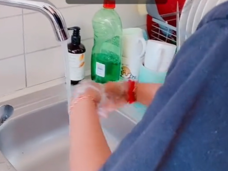 Woman washing her hands with dishwashing liquid