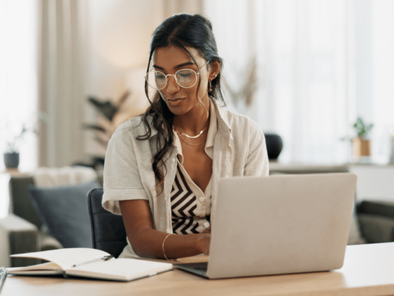 Woman wearing glasses busy on a laptop